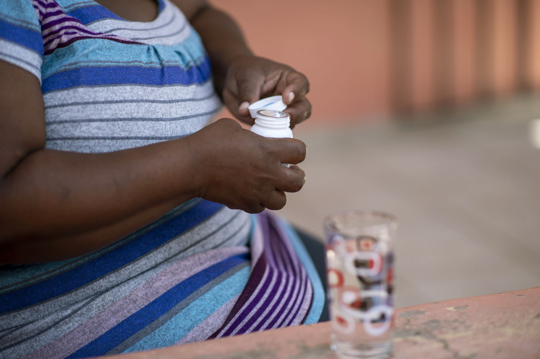 Dora takes her HIV medication in her place in Serowe village, Botswana